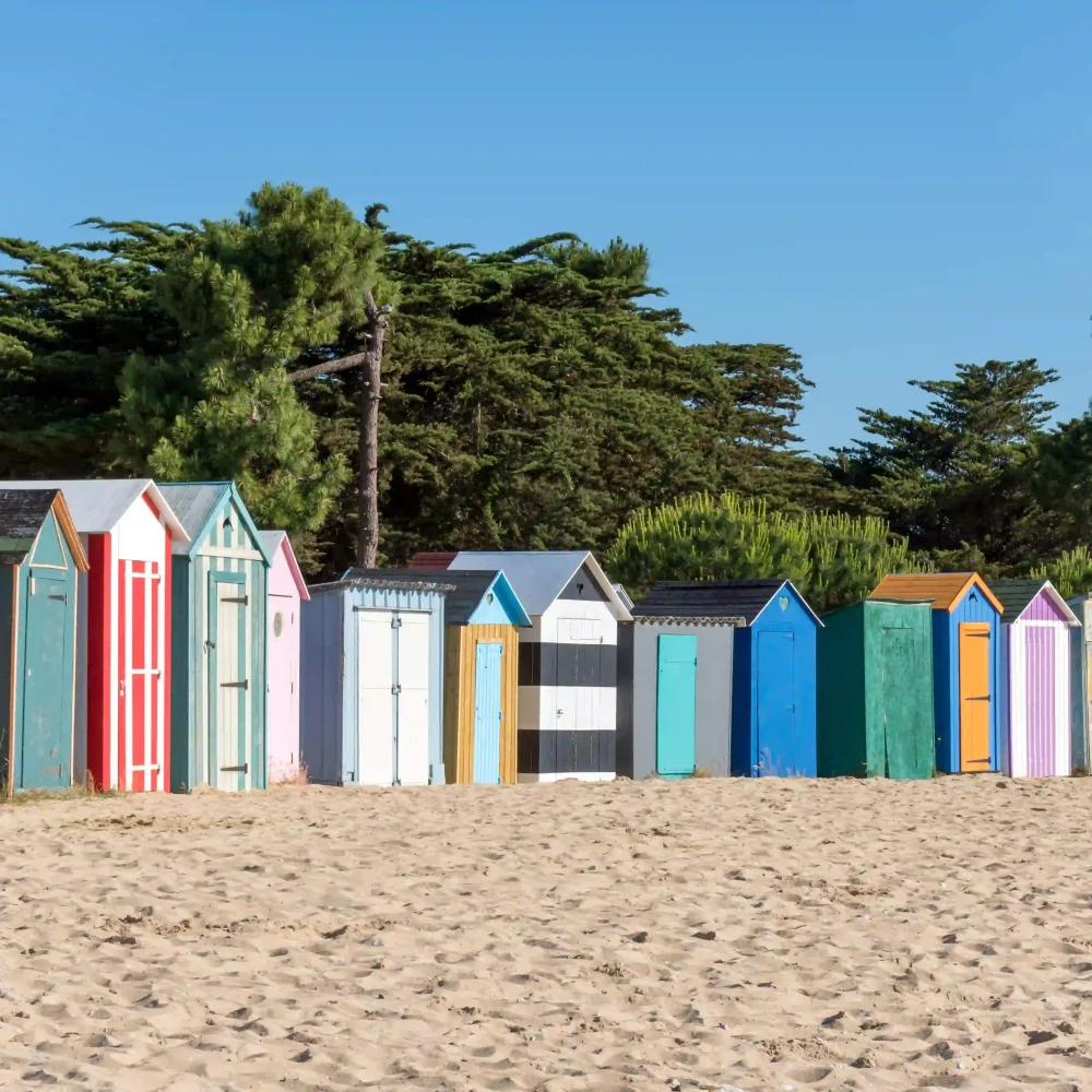 Cabanes de plage colorées sur le sable, été.