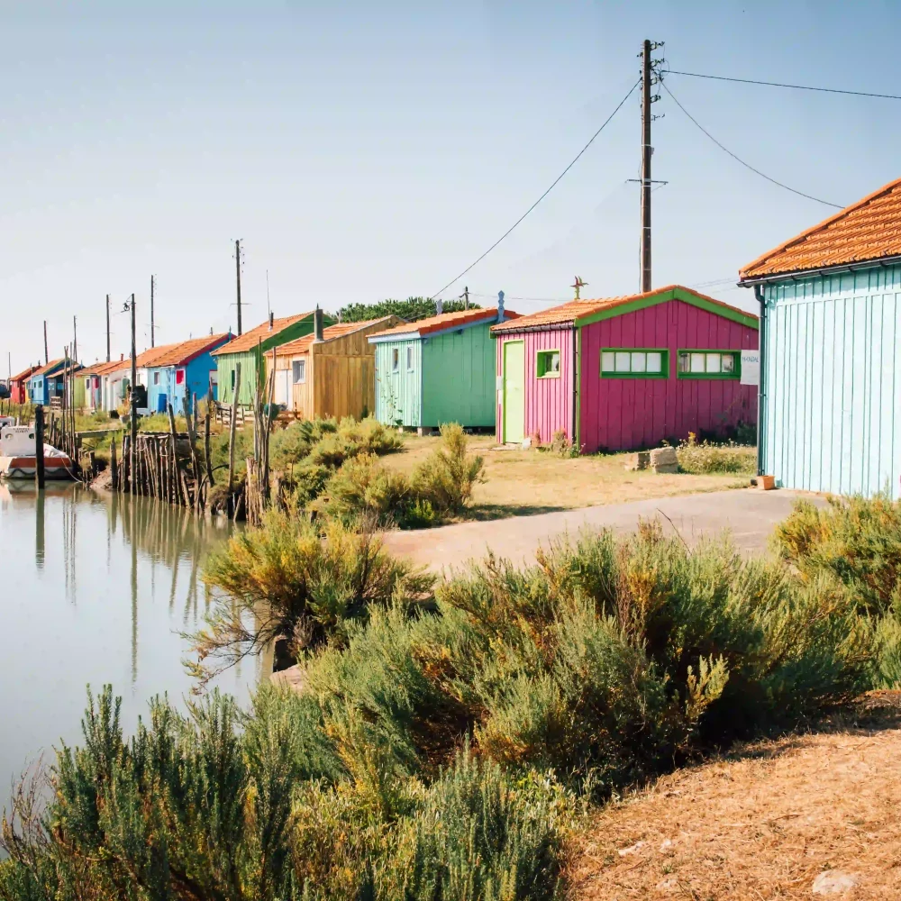 Cabines colorées le long du canal ensoleillé.